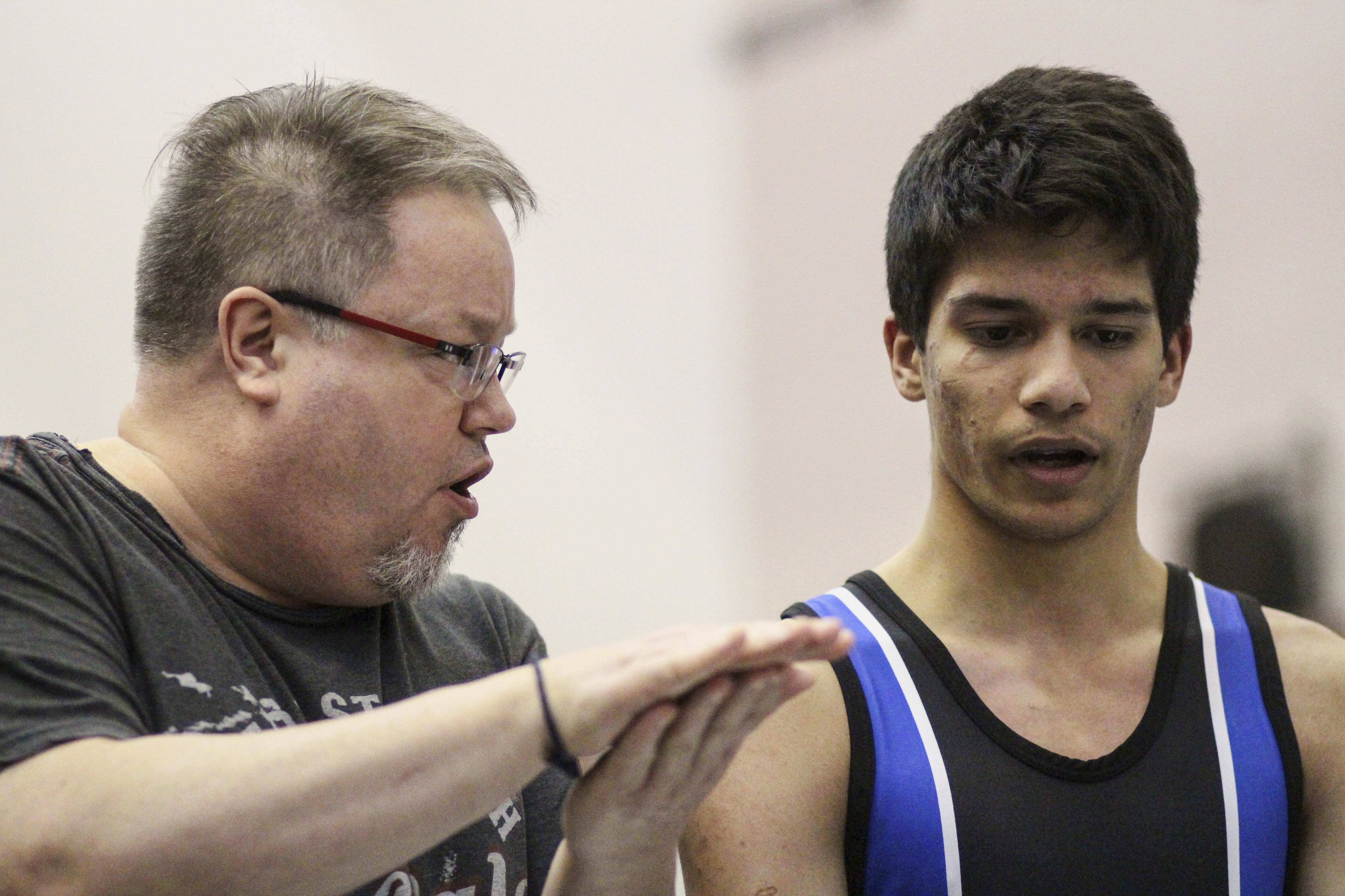 Huzaifa Moazzam from John G. Diefenbaker High School, right, talks to his coach after winning a 56 kg group match for the CSHSSA city championship in Calgary on Tuesday, Feb. 25, 2020. The game takes place at Bishop Grandin High School. (Photo by Meng Wei/SAIT)